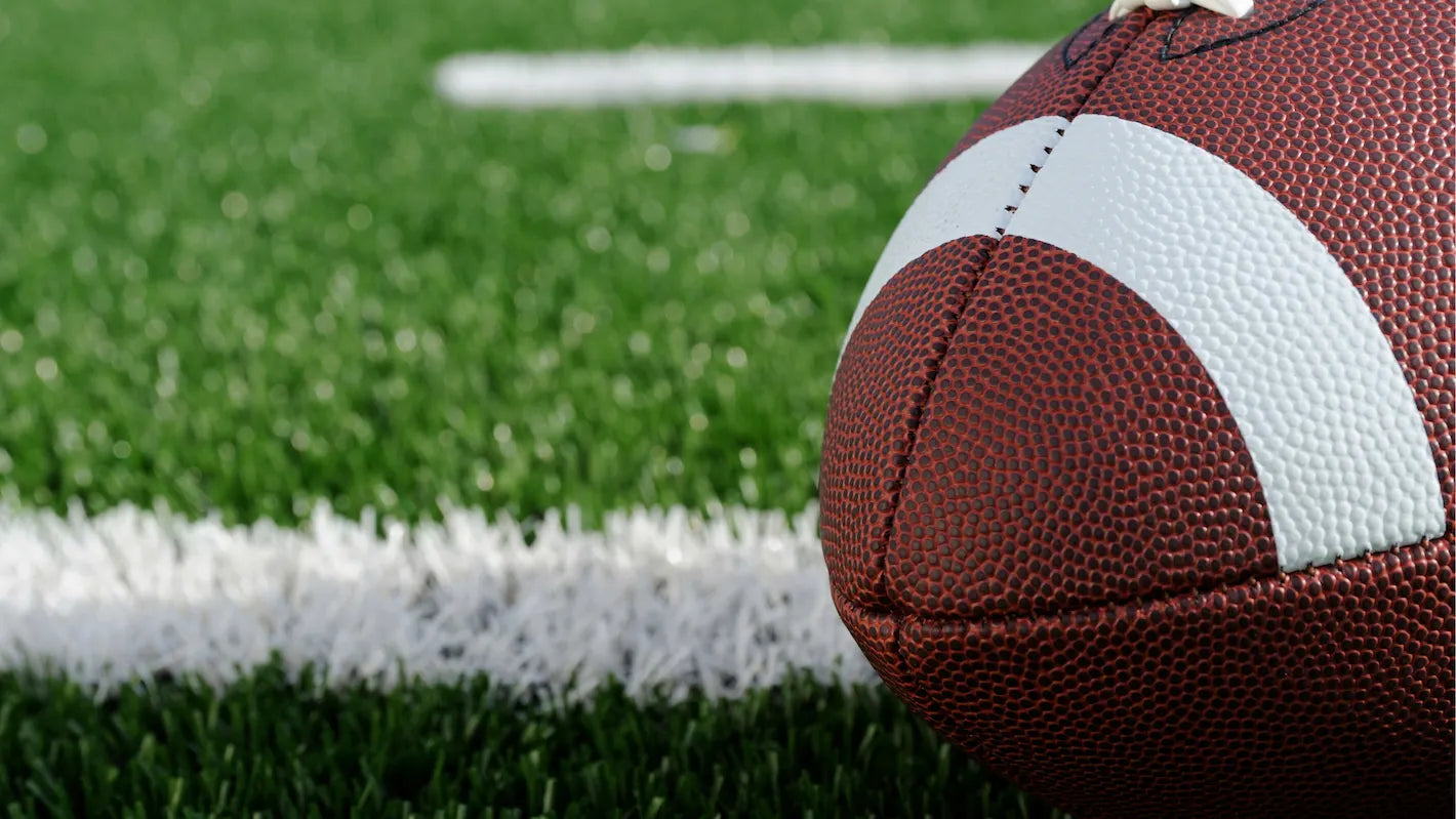 Football on turf field representing big game food and THC-infused recipe ideas for game day